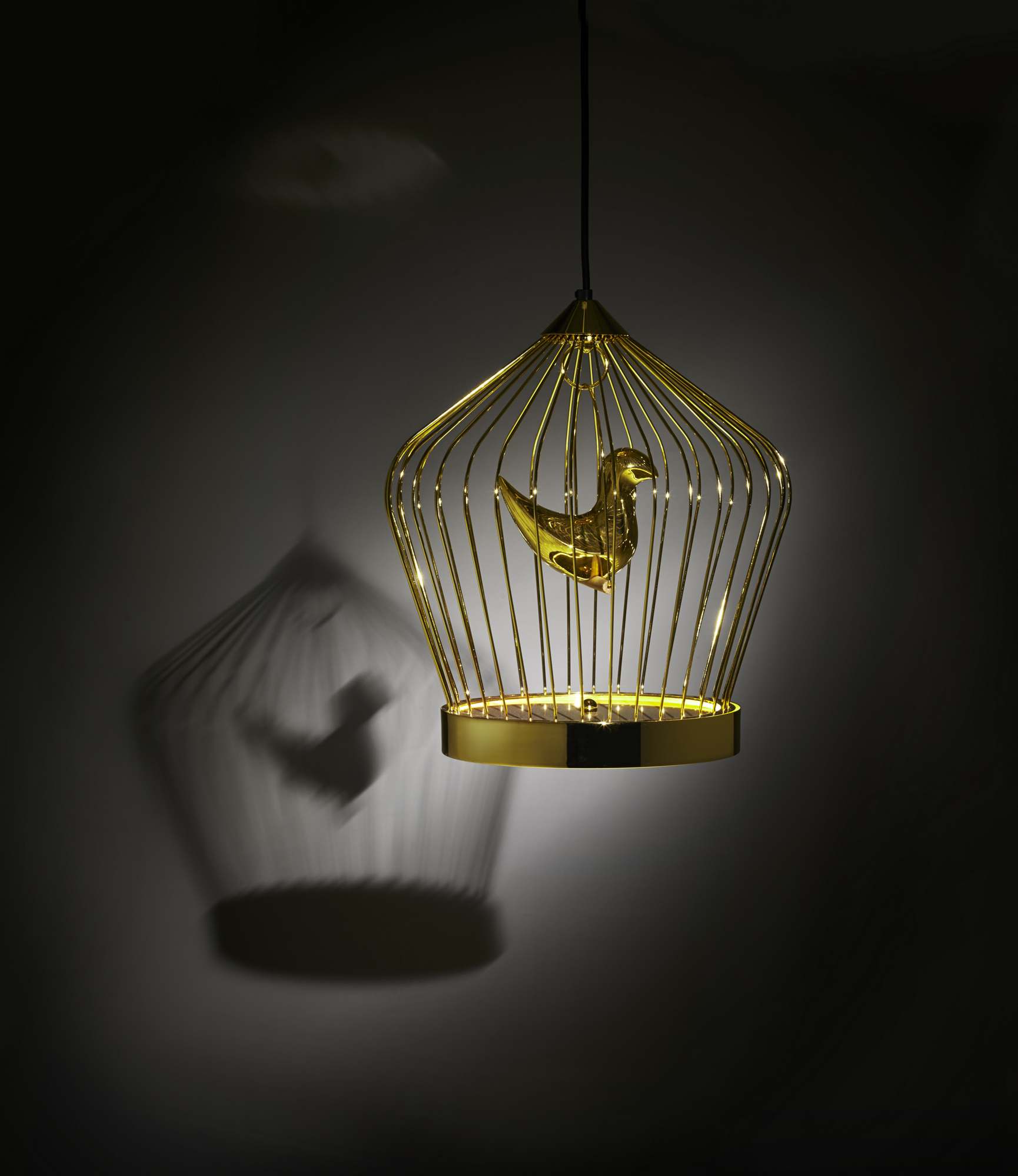 Goldene Twee T. Hängeleuchte von Casamania Horm mit Vogel im Käfig und Schattenwurf.