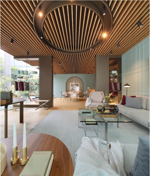 Heller Wohnraum mit Fritz Hansen PK91 Falthocker, Designermöbeln und stilvoller Deckengestaltung für modernes Wohnen.