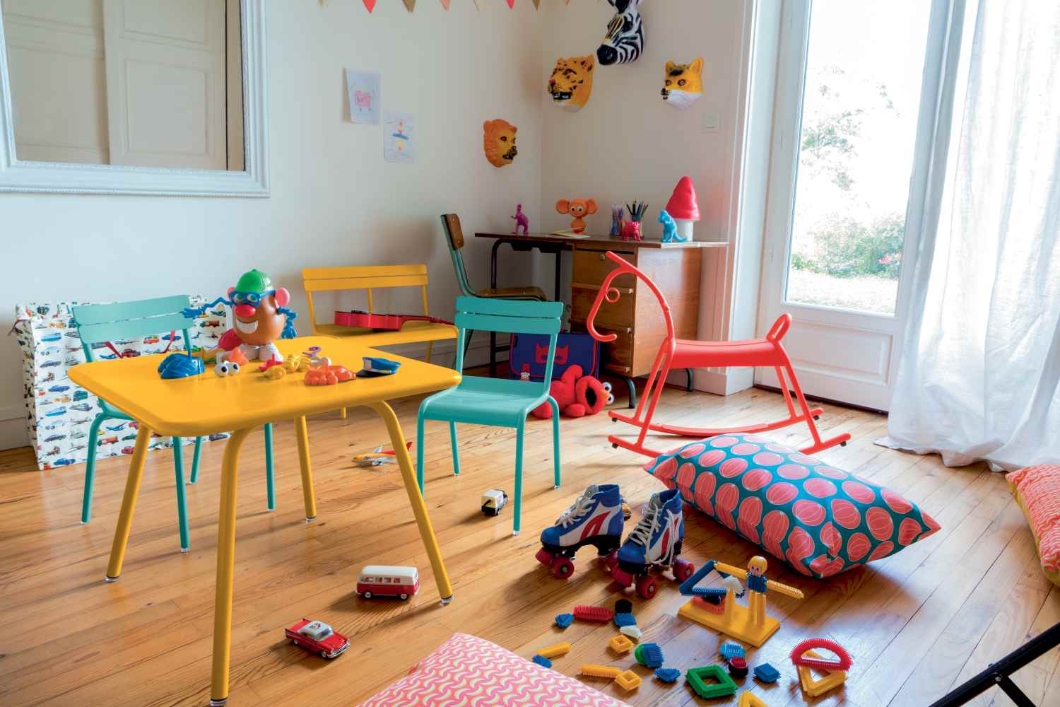 Buntes Kinderzimmer mit gelbem Luxembourg Kindertisch und Stühlen von Fermob, Spielzeug und Deko für Kinder.