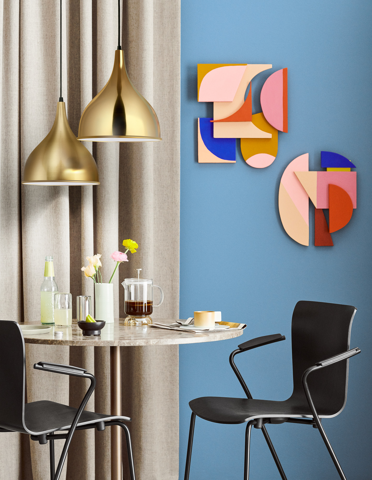 Esszimmer mit Marmortisch, zwei schwarzen Vico Stühlen von Fritz Hansen und goldenen Hängelampen.