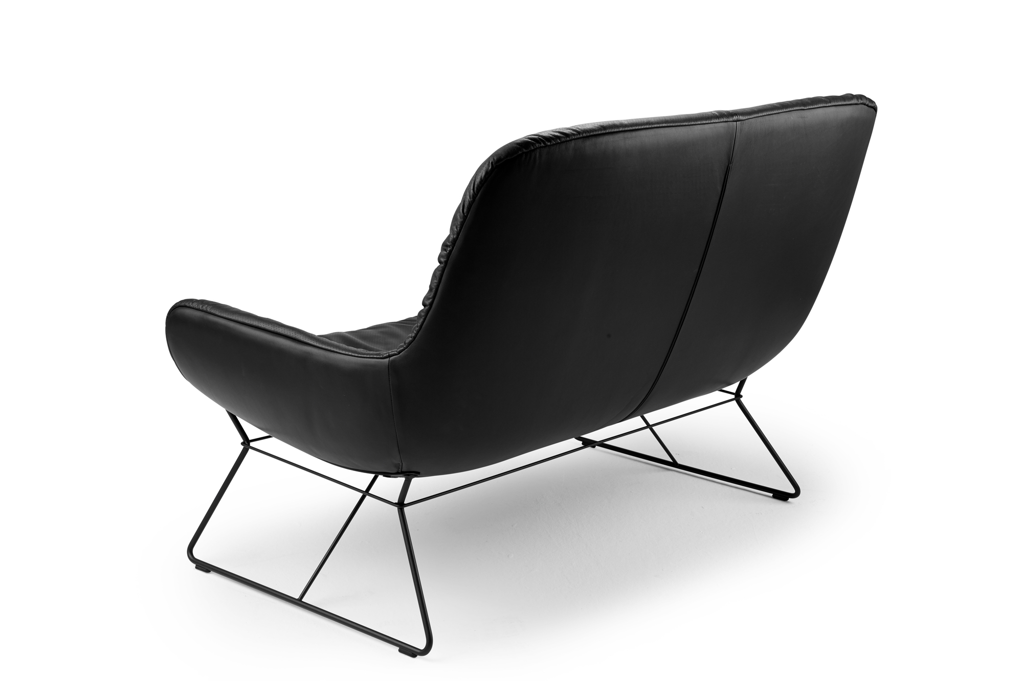 Schwarze Leya Loungecouch der Freifrau Manufaktur, Rückansicht mit filigranem, schwarzem Metallgestell auf weißem Hintergrund.