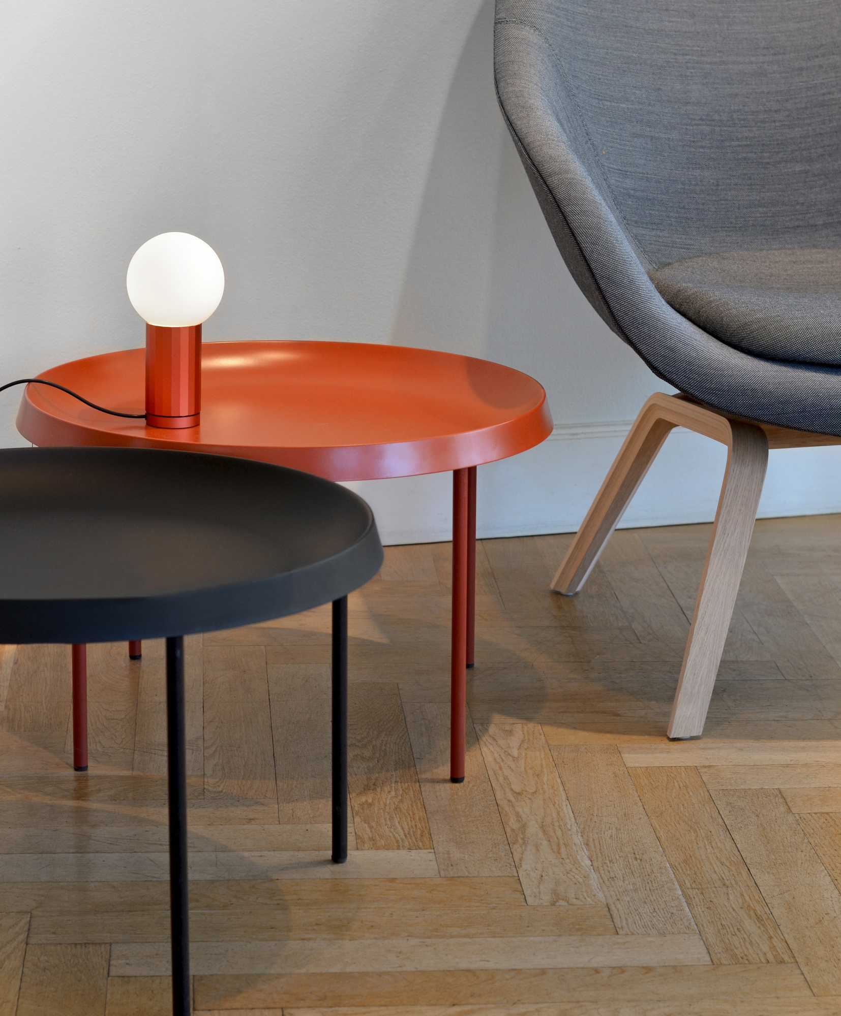 Detailaufnahme von About a Lounge AAL 83 Sessel von Hay, mit Beistelltischen und Lampe.
