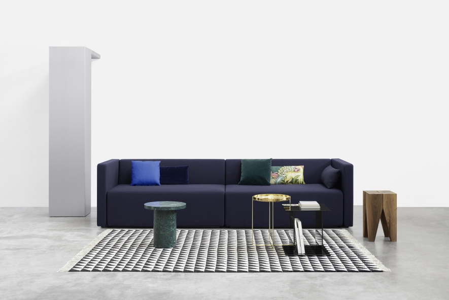 SF06 Kerman Modulsofa von e15 in Dunkelblau mit Kissen und Beistelltischen auf Teppich.