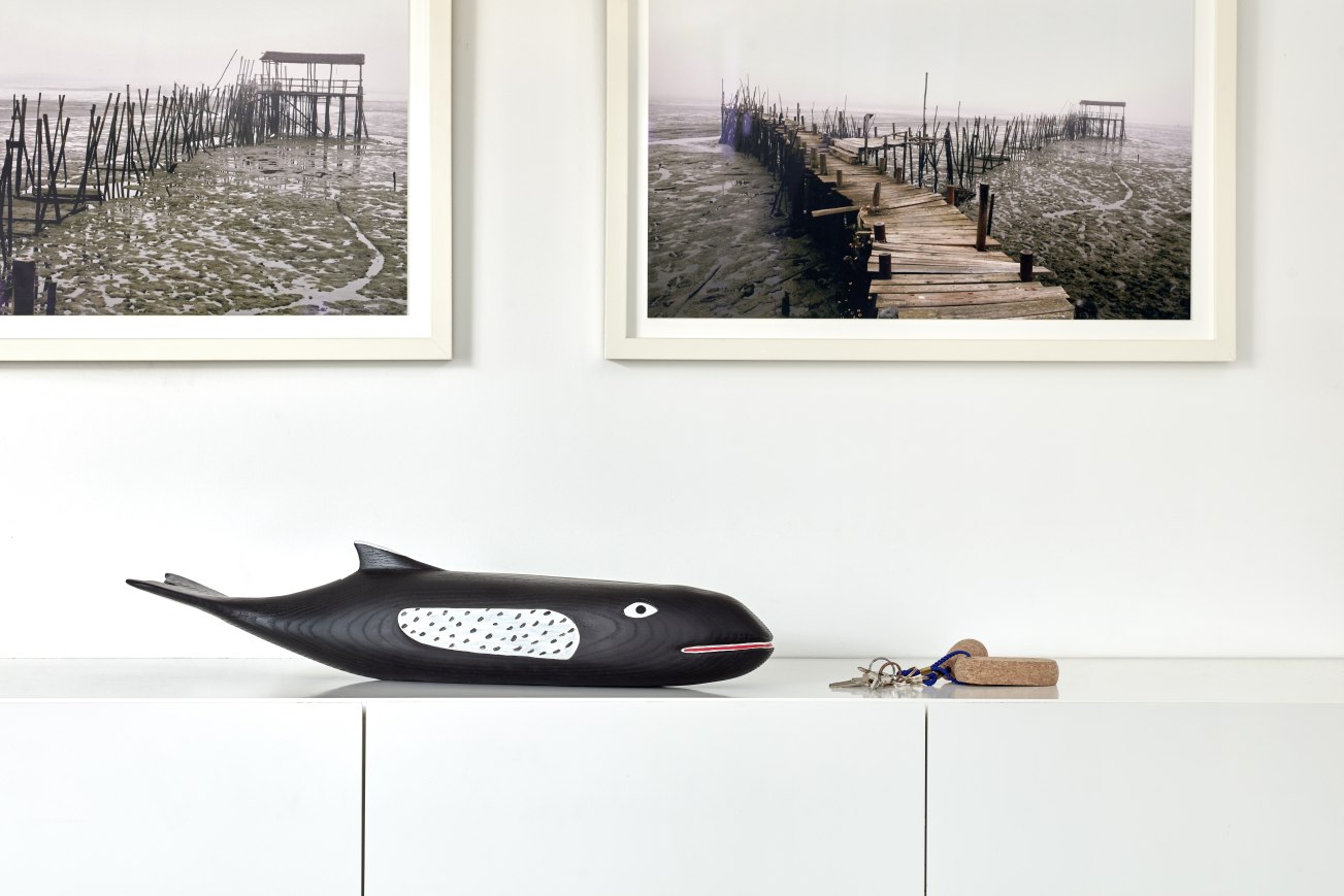 Eames House Whale Skulptur aus Esche von Vitra auf einem weißen Sideboard mit Schlüsseln.