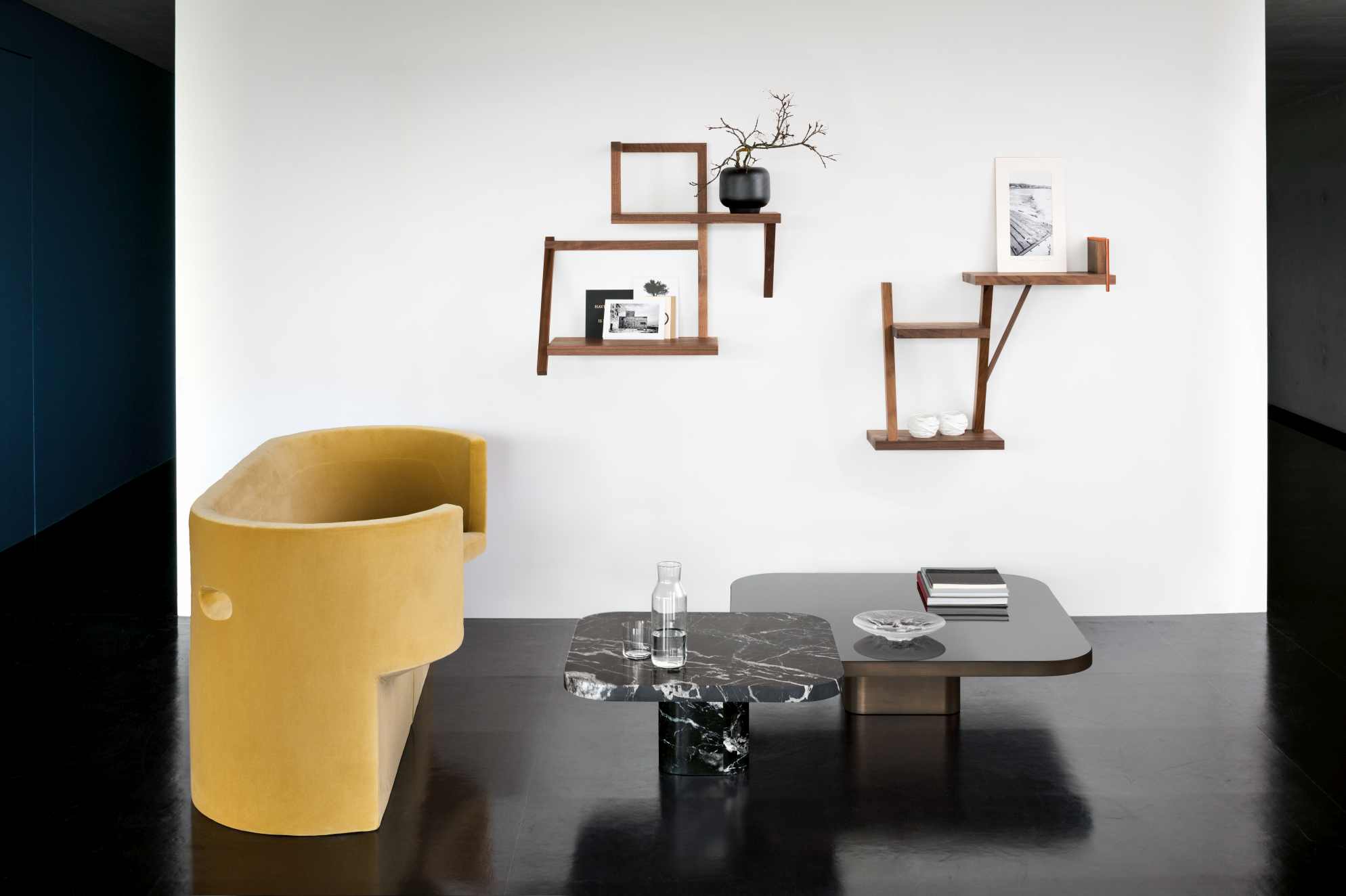 Wohnzimmer-Szene mit gelbem Sessel und ClassiCon Bow Coffee Table Couchtisch mit Marmorplatte und Glasplatte.