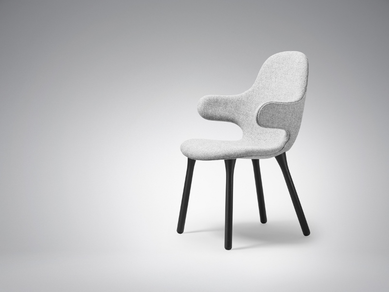 AndTradition Catch Chair JH1 Stuhl, hellgrauer Stoffbezug mit schwarzen Holzbeinen, modernes Möbeldesign.