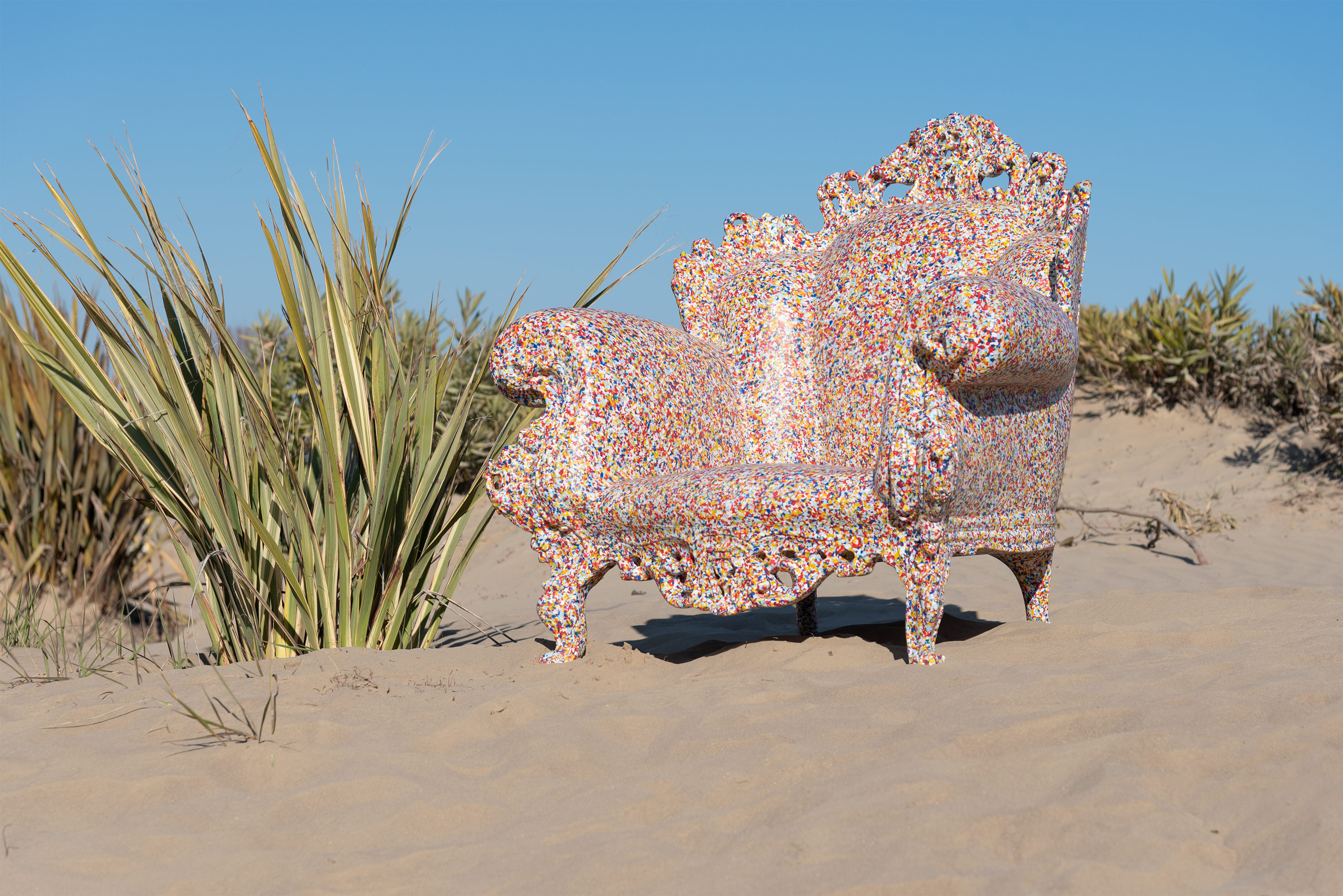 Farbenfroher Proust Sessel Outdoor von Magis auf Sandstrand mit blauem Himmel, Gartenmöbel und Design.