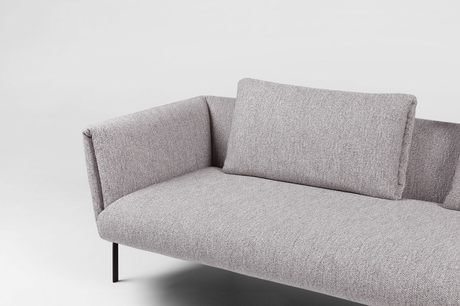 Detailaufnahme des Prostoria Impression Sofas in Grau mit Kissen und schwarzen Füßen.