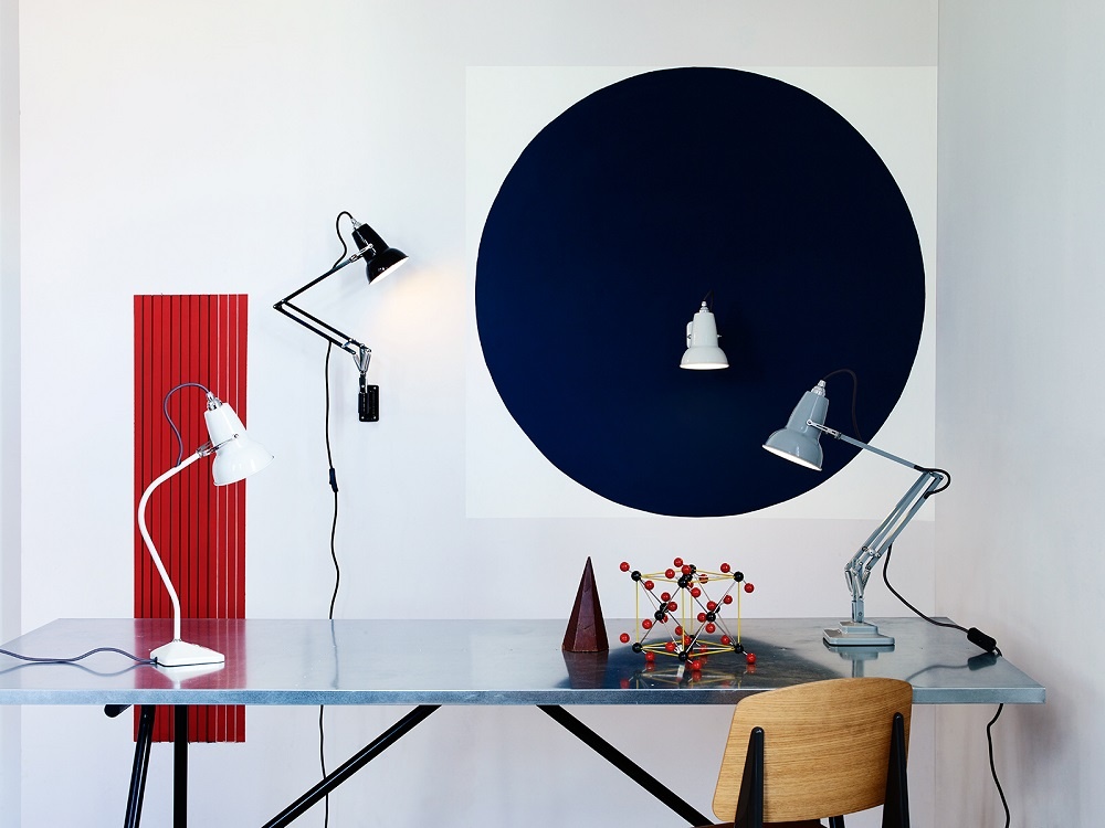 Anglepoise Original 1227 Mini Tischleuchten in verschiedenen Farben auf einem Schreibtisch arrangiert.