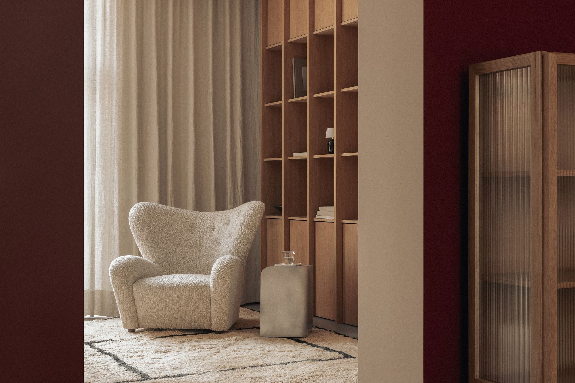 Audo Copenhagen Volume Side Table als moderner Beistelltisch im Wohnzimmer mit Sessel und Teppich.