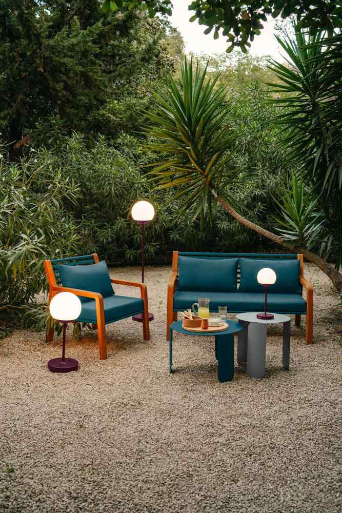 Fermob Somerset Sofa und Sessel für den Außenbereich mit Beistelltischen und Gartenbeleuchtung.