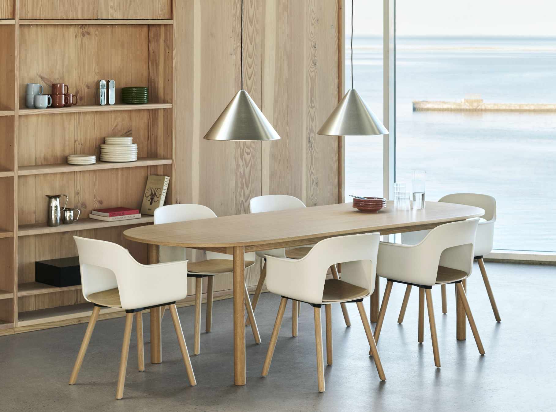 Esszimmer mit ovalem Holztisch und sechs weißen Hay Layout Armchair 222 Armlehnstühlen mit Holzbeinen.