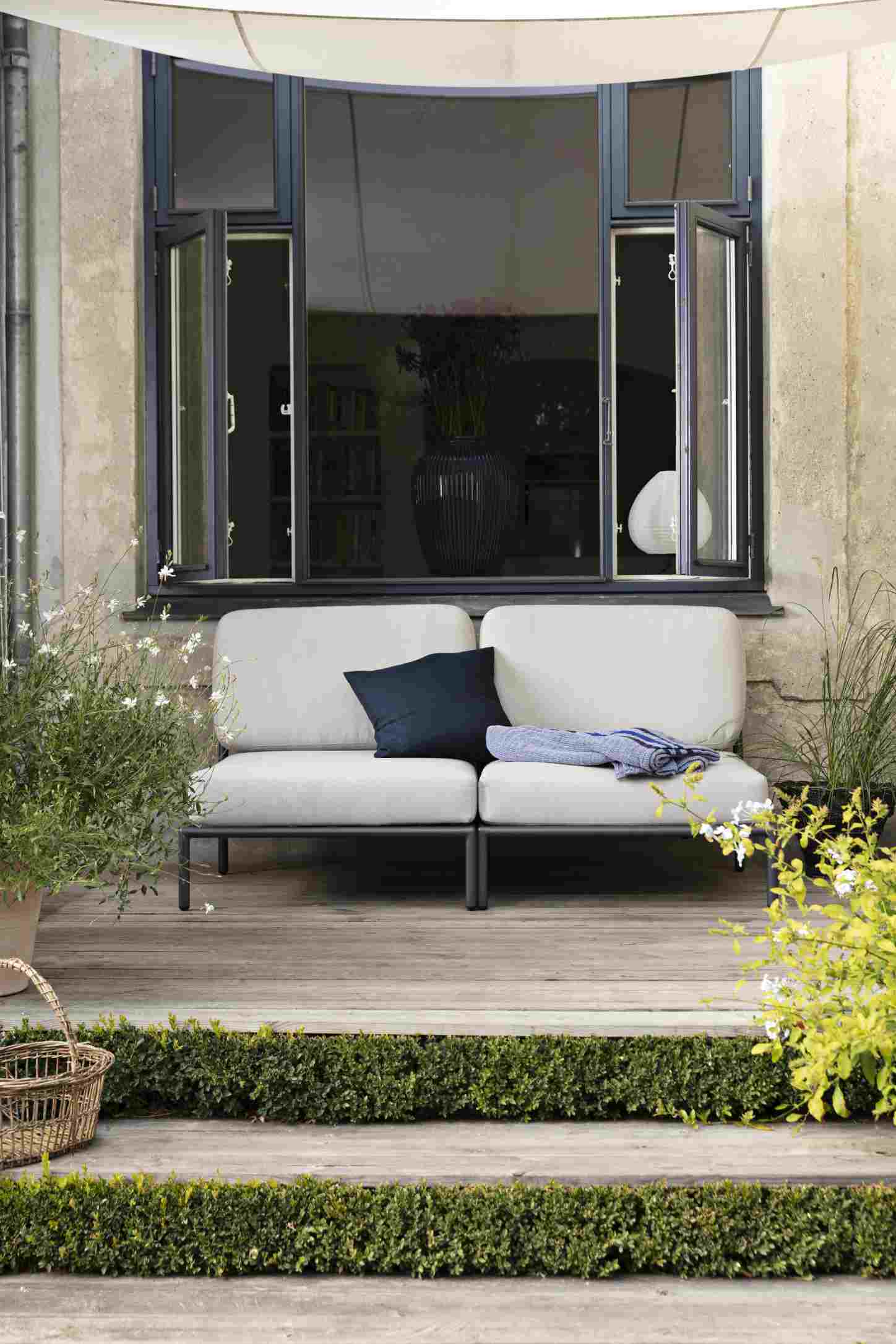 Level Lounge Chair von Houe: Outdoor Sessel mit grauen Polstern und schwarzem Rahmen auf Holzterrasse.