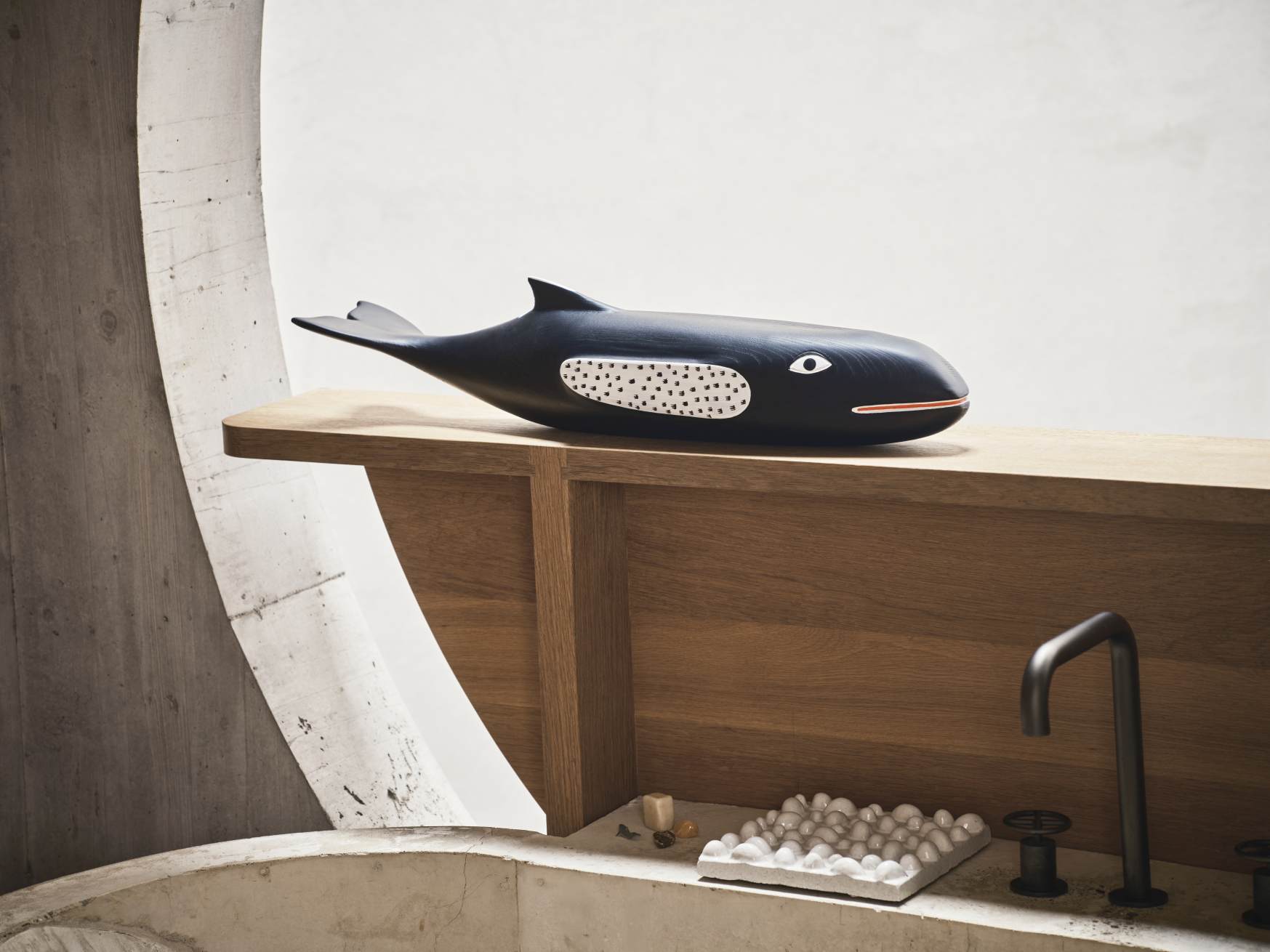 Nahaufnahme der Vitra Eames House Whale Holzskulptur aus Esche auf einem Holzregal im Badezimmer.