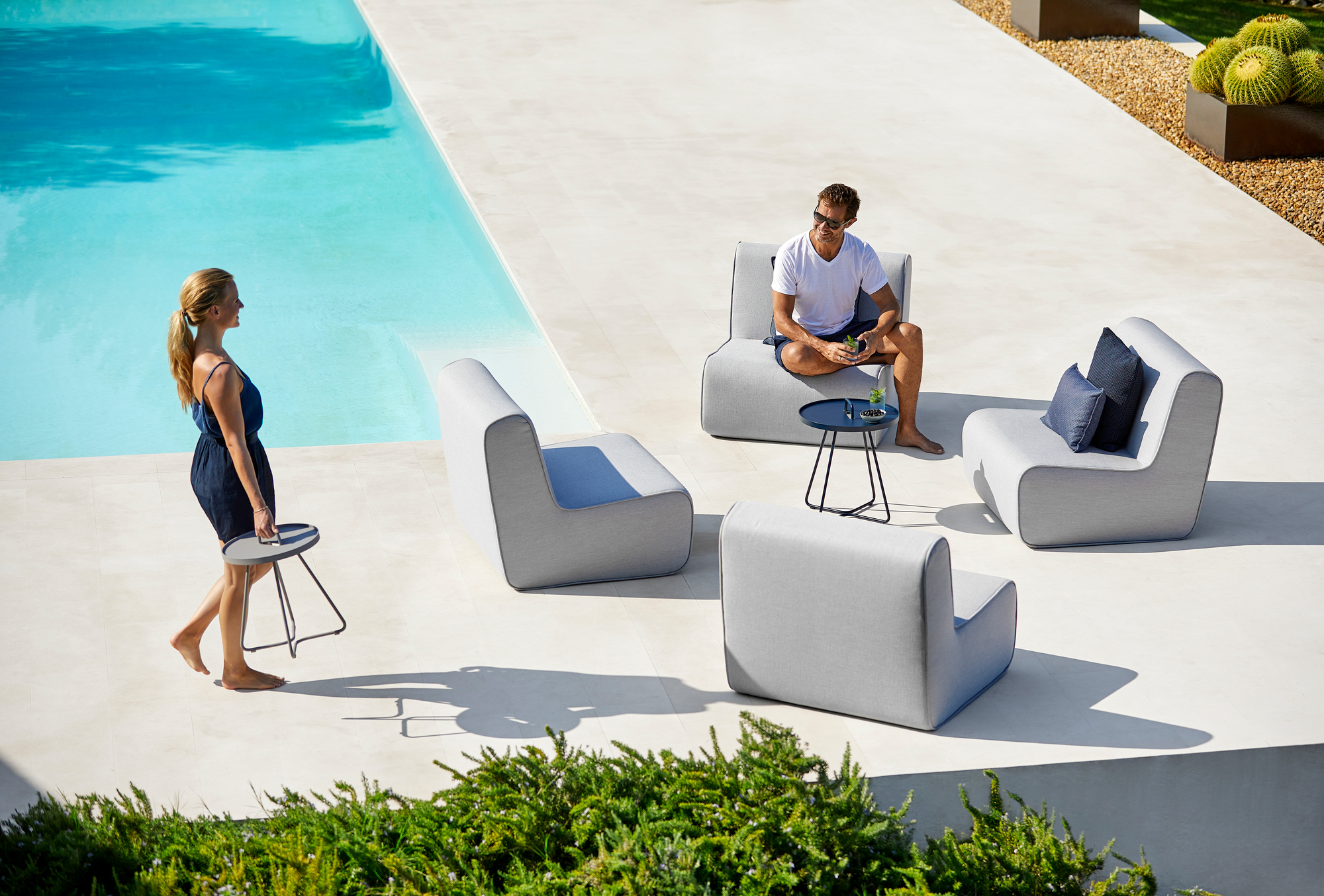 Szene mit Cane-Line Outdoor Möbeln: Lounge Sessel und On-The-Move Beistelltisch in Schwarz.
