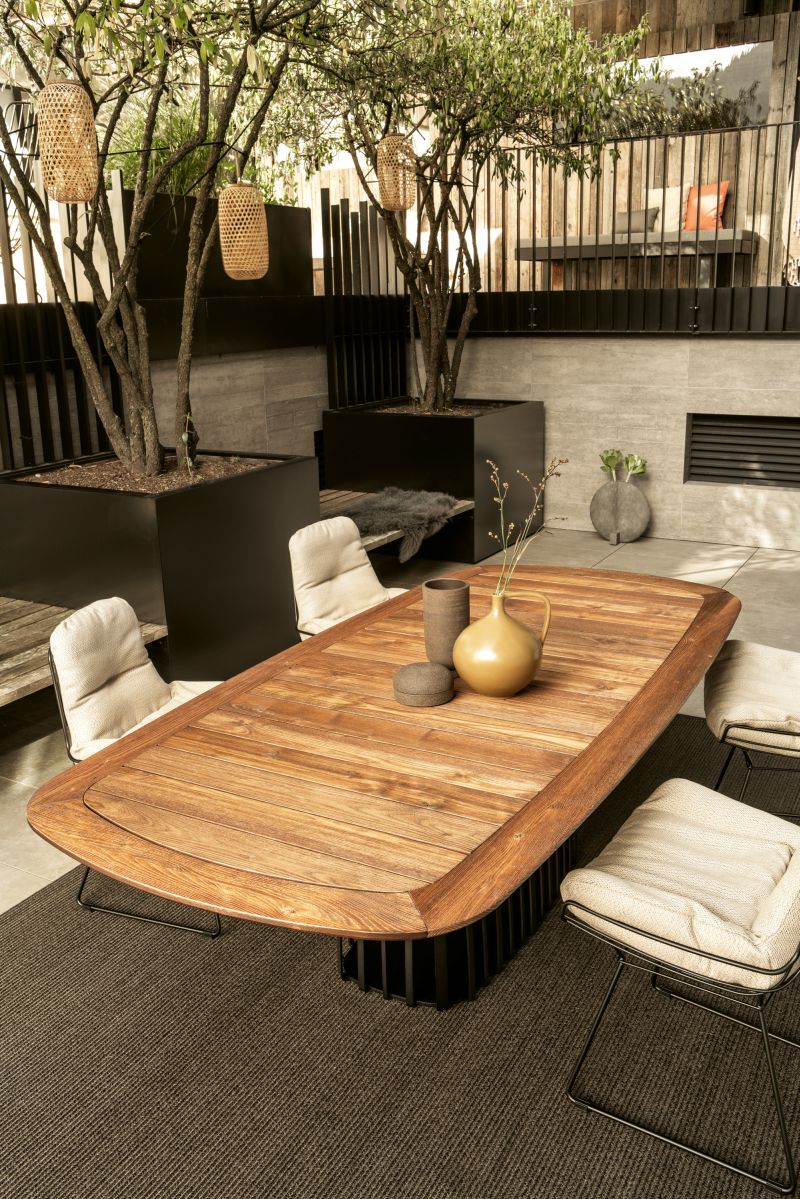 BC 07 Basket Outdoor Tisch von Janua: Bootsförmiger Holztisch mit Stühlen im Garten.