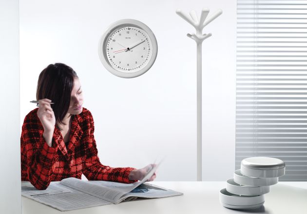 Weißer Pop Kleiderständer von Rexite im modernen Büro mit Frau und Uhr.