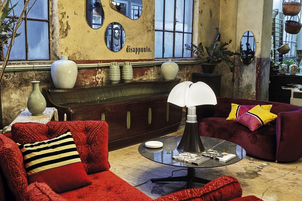 Nahaufnahme der Pipistrello Tischleuchte von Martinelli Luce auf einem Couchtisch in einem Wohnzimmer.