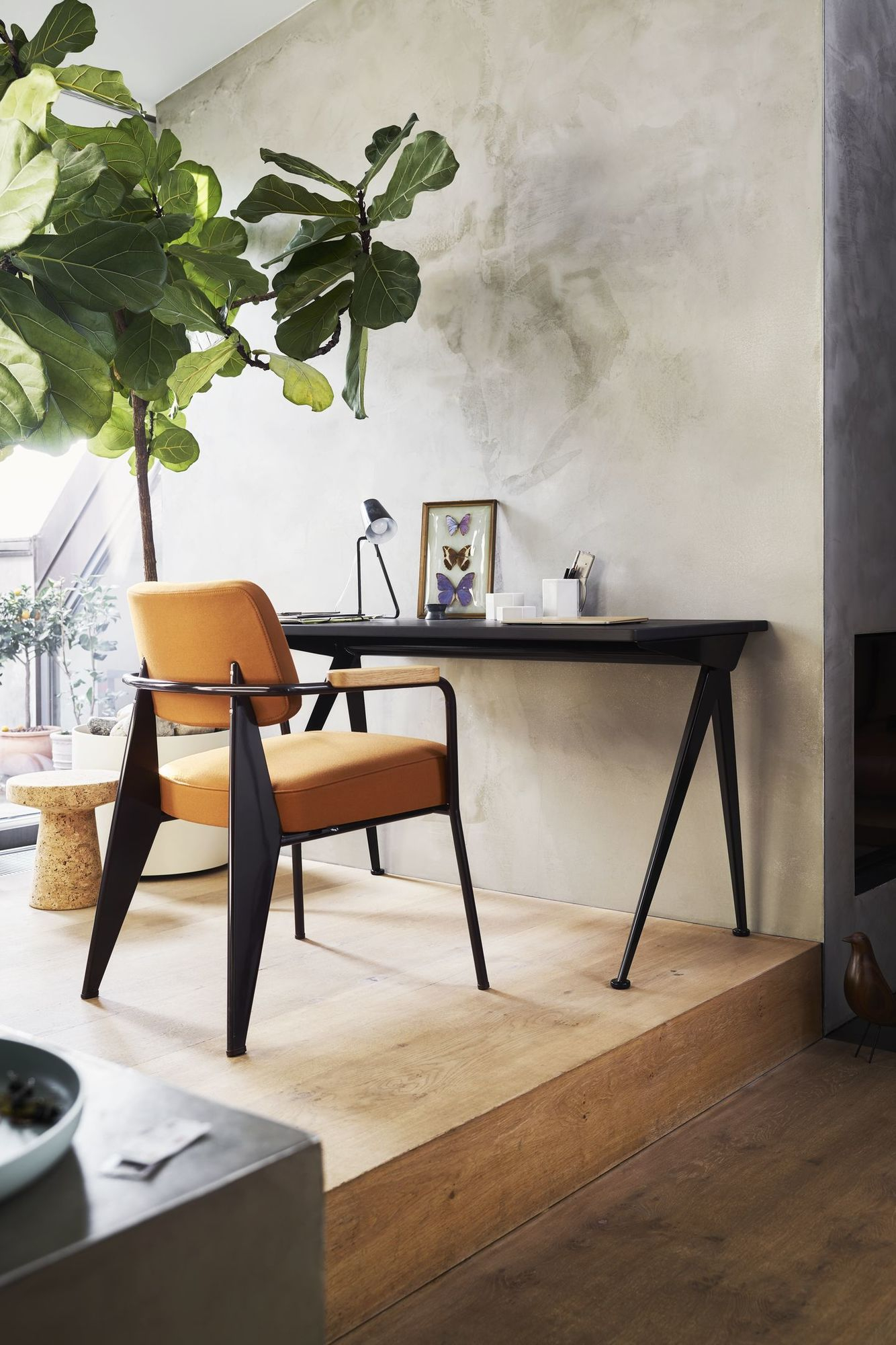 Fauteuil Direction Sessel von Vitra in orange am Schreibtisch, modernes Wohnambiente mit Zimmerpflanze.