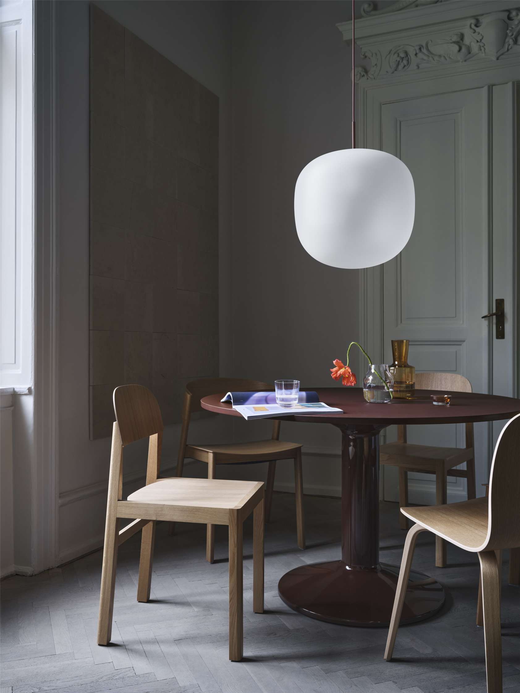 MIDST Table Esstisch von Muuto in dunklem Esszimmer mit Holzstühlen und Pendelleuchte.