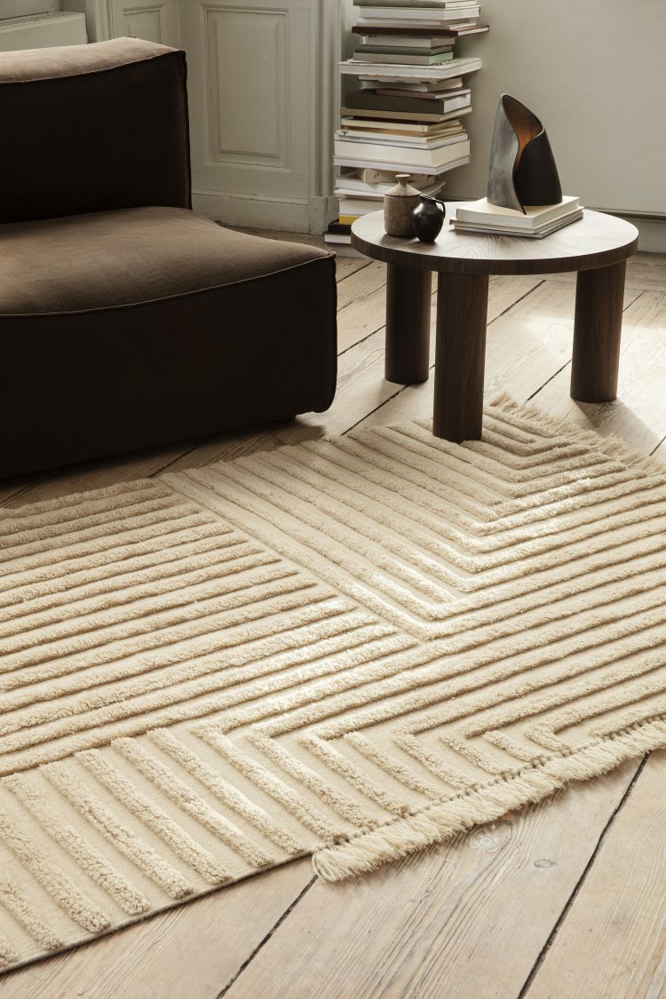 Nahaufnahme des beigen Kelim-Teppichs mit geometrischem Muster von Ferm Living im Wohnzimmer.