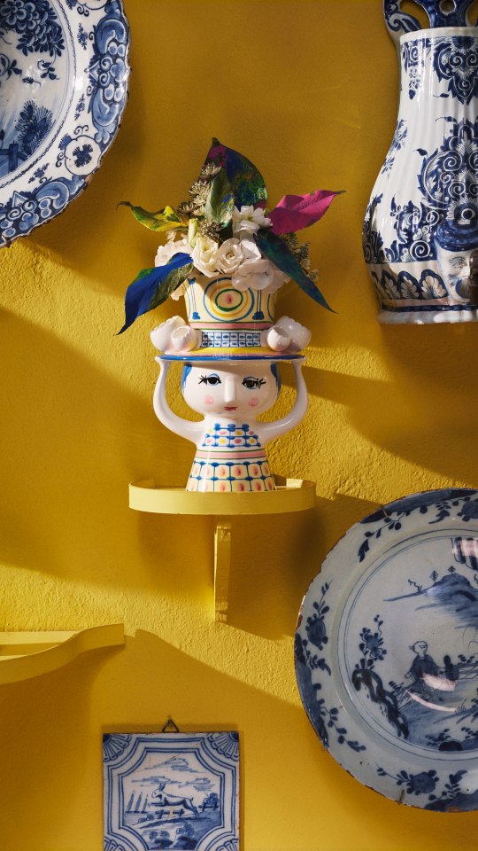 Dekorative Bjorn Wiinblad "Lady with Hat" Porzellanvase, Höhe 20,5 cm, mit Blumen auf gelber Wand.
