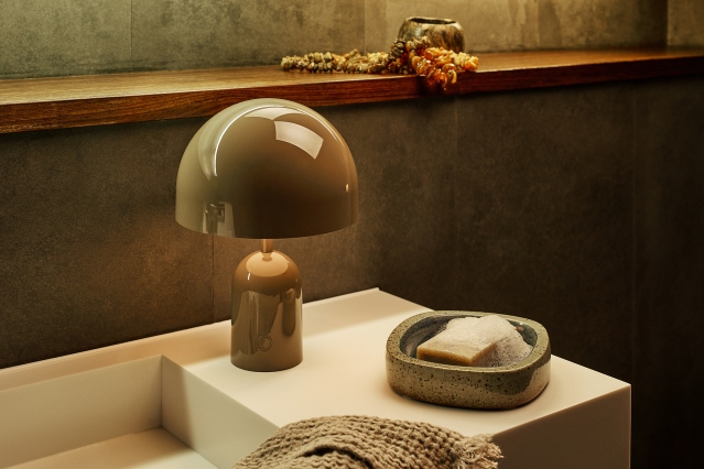 Bell Portable LED Tischleuchte von Tom Dixon in Kupfer auf einem Waschtisch.