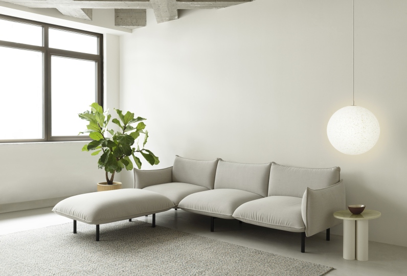 Helles Wohnzimmer mit modularem Sofa, Ottomane, Zimmerpflanze und Normann Copenhagen Dit Coffee Table Beistelltisch.