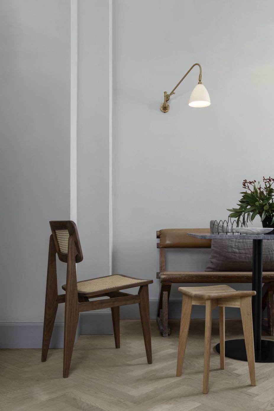 Bestlite Wandleuchte BL6 in Chrom und Weiß an grauer Wand über Essbereich.