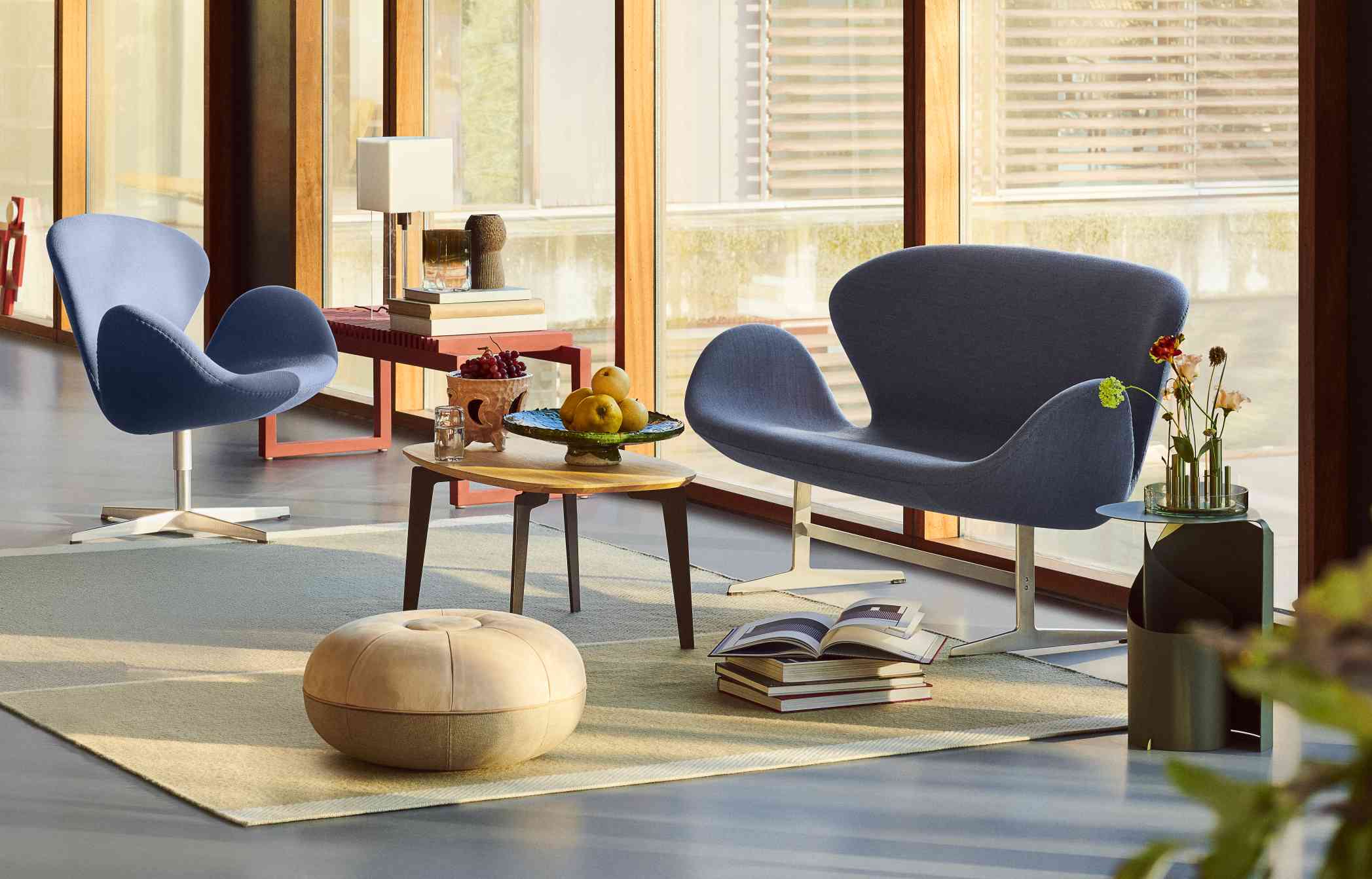 Blaues Swan Sofa von Fritz Hansen in stilvollem Wohnzimmer mit Designermöbeln und Tageslicht.