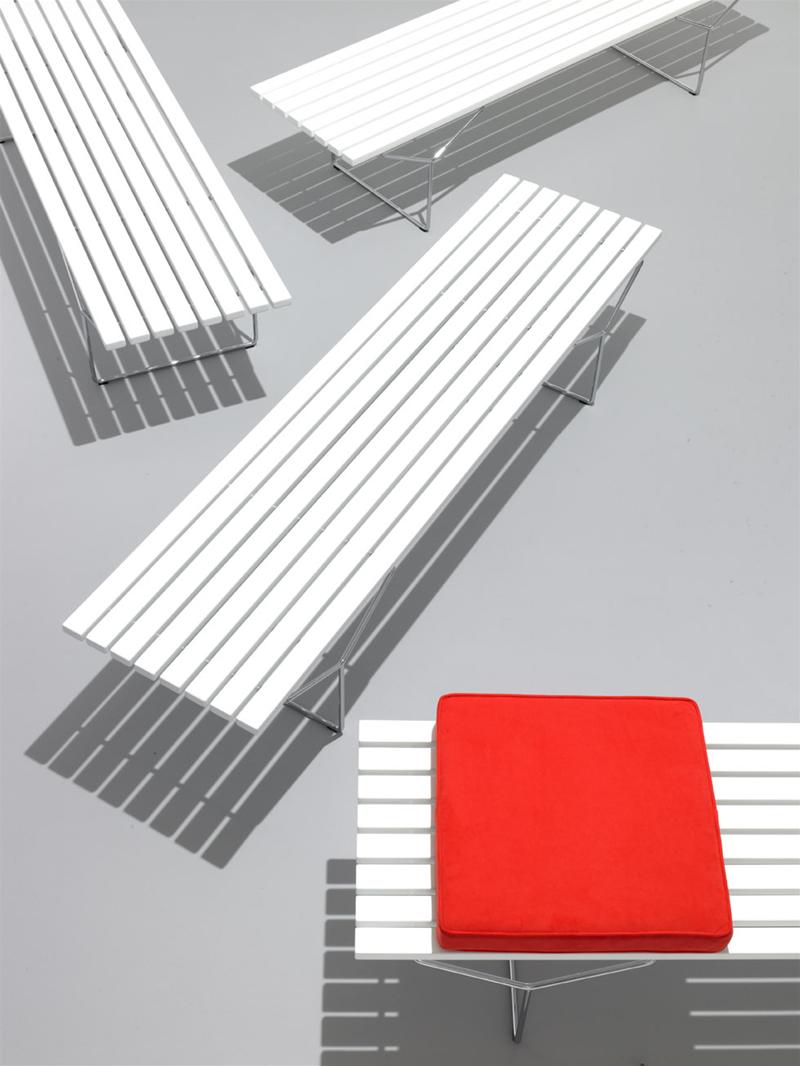 Bertoia Bank von Knoll International, weiße Sitzbänke für Innen und Außen mit rotem Sitzkissen.