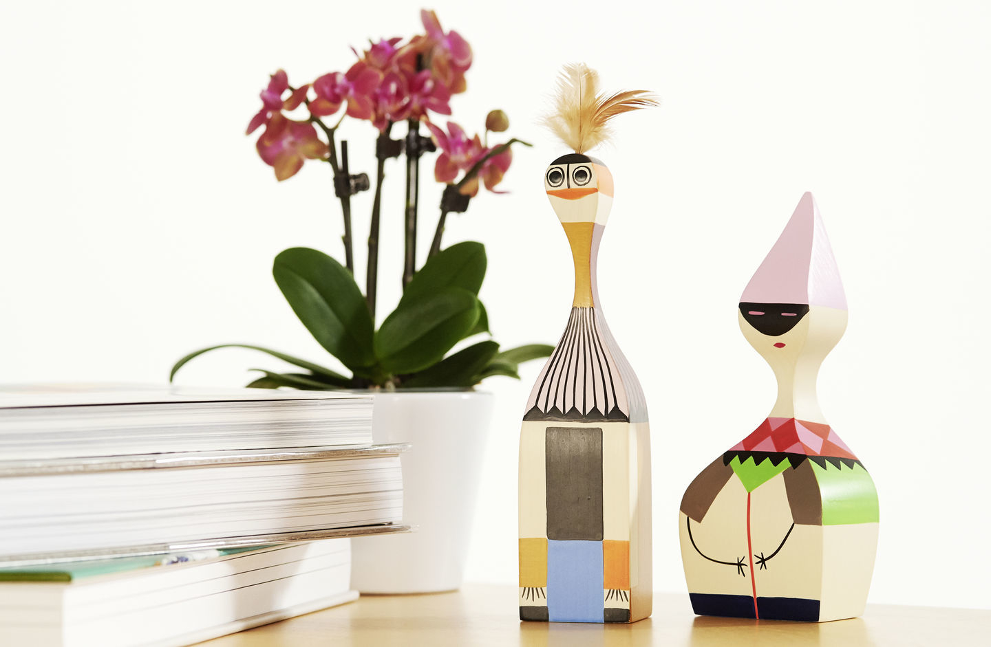 Holzfiguren von Vitra Wooden Dolls, dekorative Sammlerstücke im skandinavischen Design mit Orchidee und Büchern.