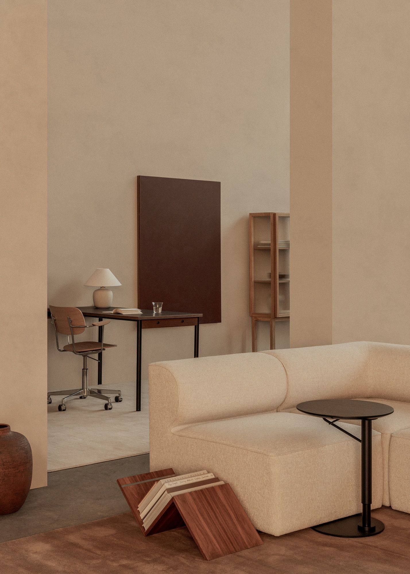 Beige Inneneinrichtung mit Audo Copenhagen Curiosity Cabinet, Schreibtisch, Sofa und Beistelltisch in harmonischen Erdtönen.