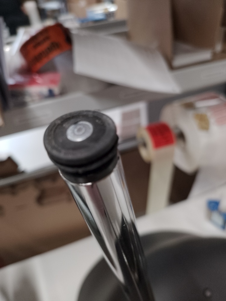 Detailaufnahme vom Fuß eines schwarzen About A Chair AAC26 Stuhls mit Chromgestell, Mängelexemplar.