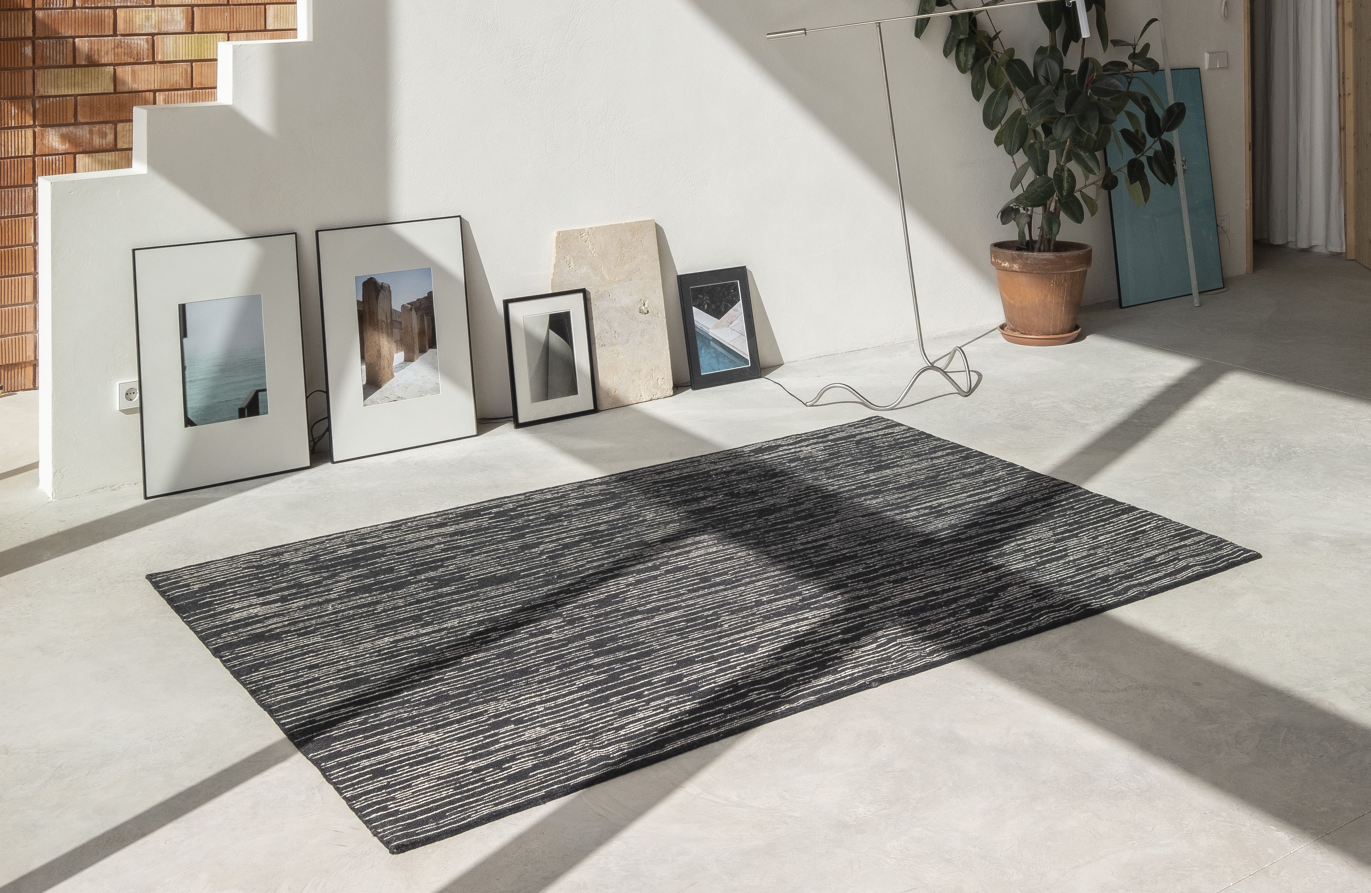 Doblecara Rug Teppich von Nanimarquina, schwarzer Wollteppich mit abstraktem Muster im modernen Wohnzimmer.