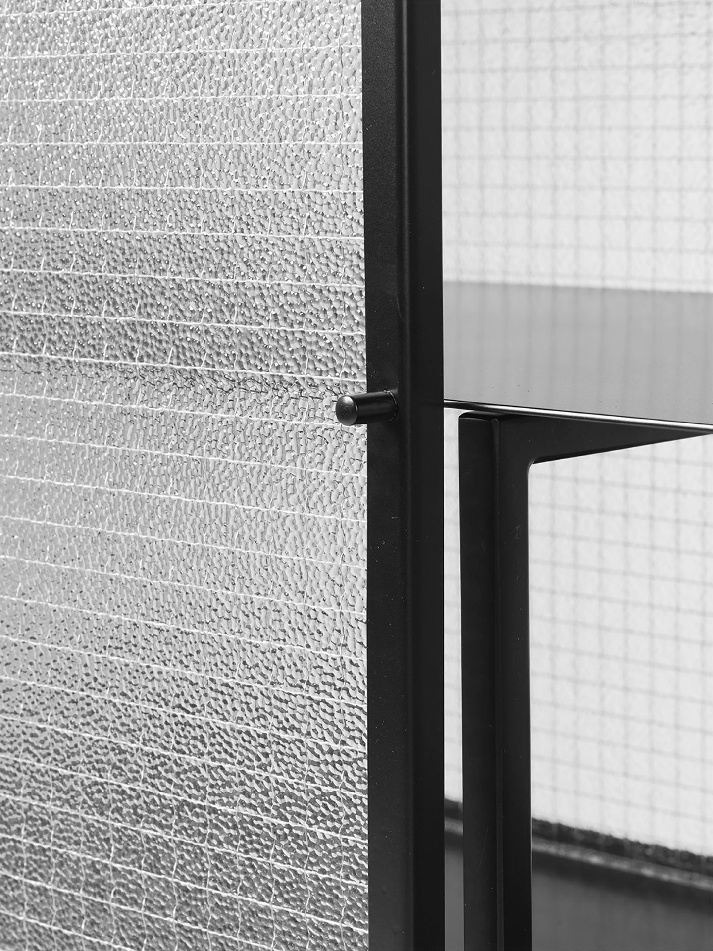 Detailaufnahme: Schwarzes Haze Sideboard von Ferm Living mit geriffeltem Glas und Metallrahmen.
