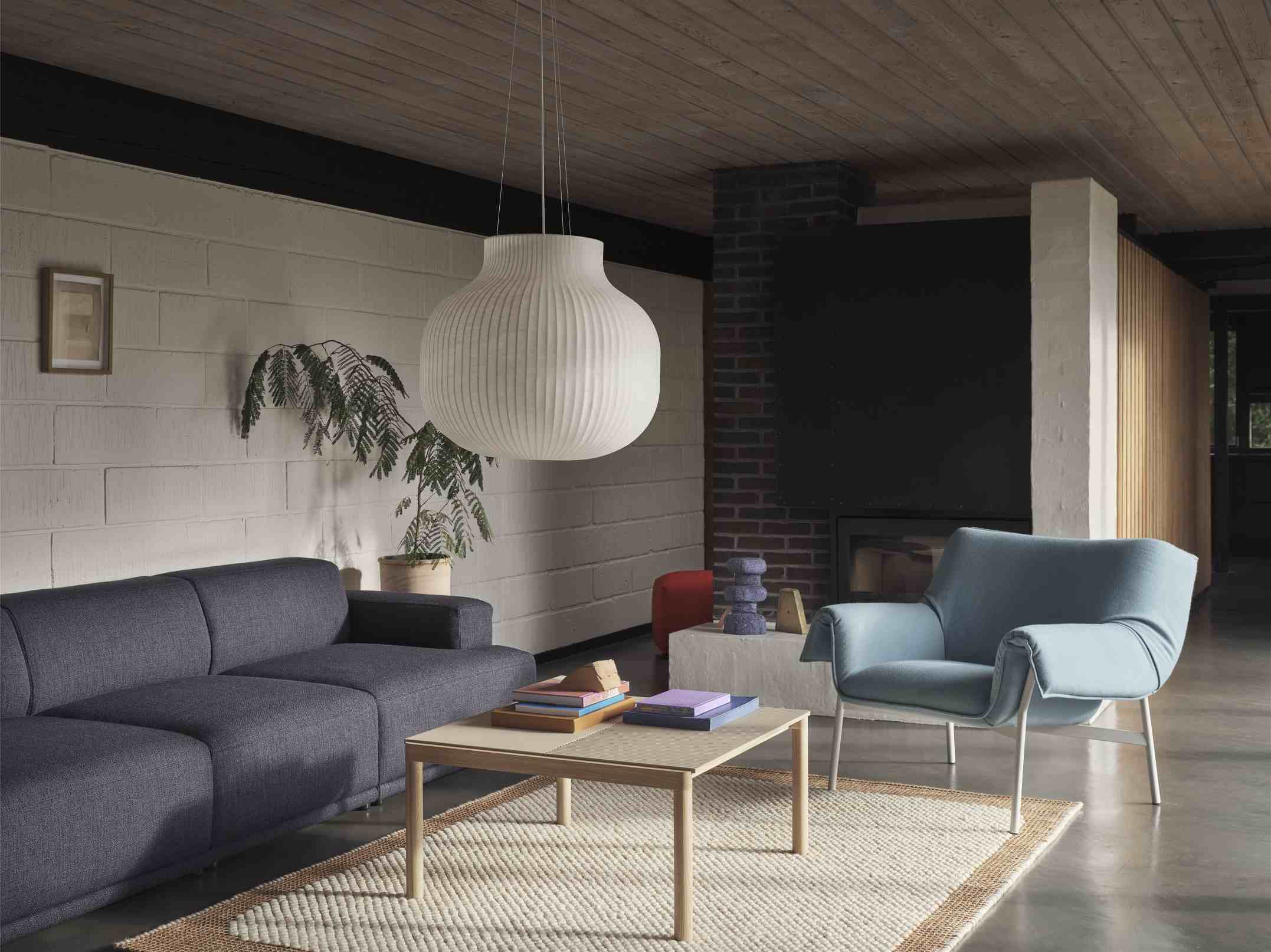 Wohnzimmer Interieur mit Muuto Couple Coffee Table Couchtisch, Sofa, Sessel, Teppich und Hängelampe in modernem Design.