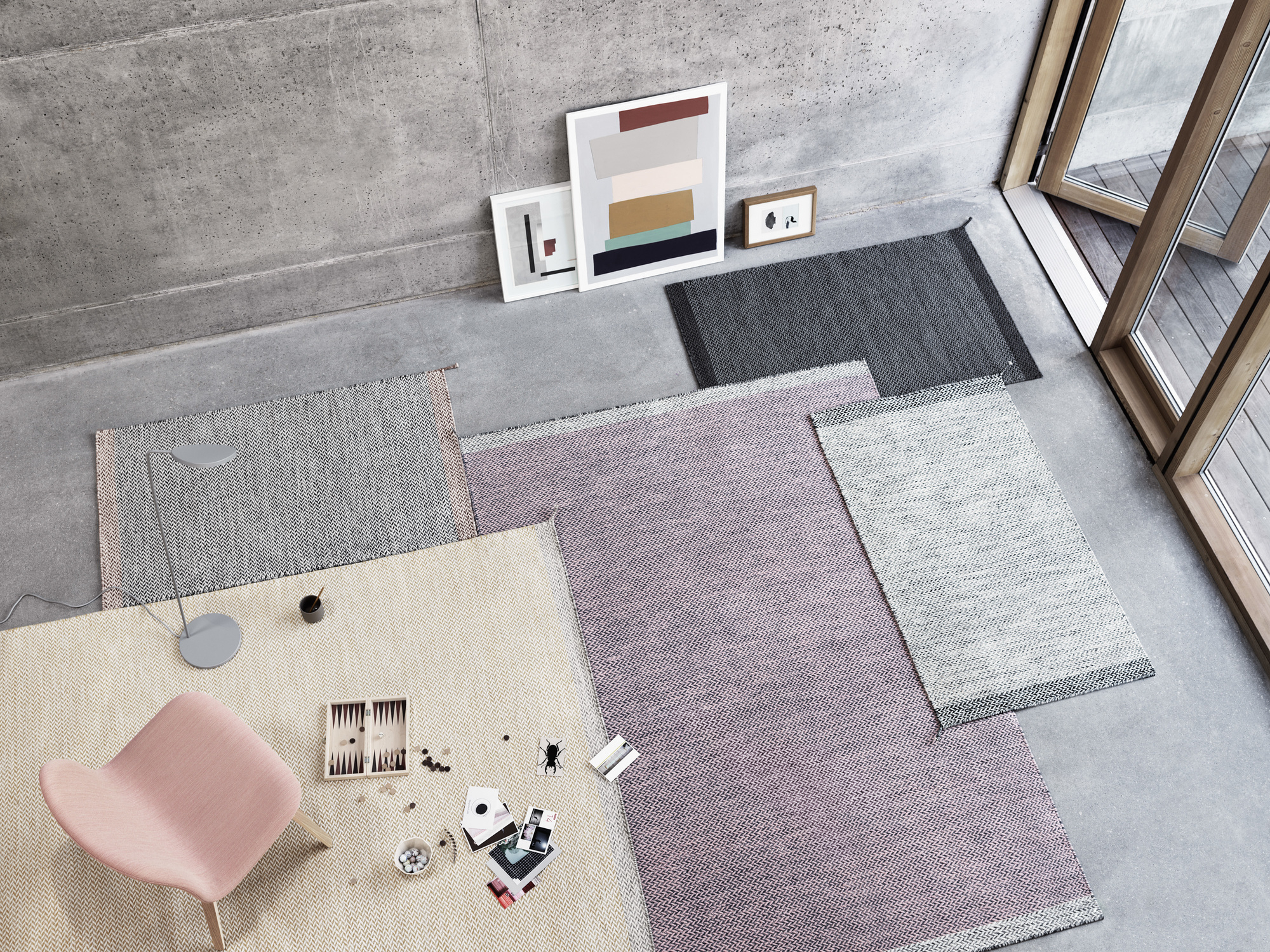 Ansicht von oben: Rosa Muuto Visu Lounge Chair Stuhl auf beigem Teppich mit Spielbrett.