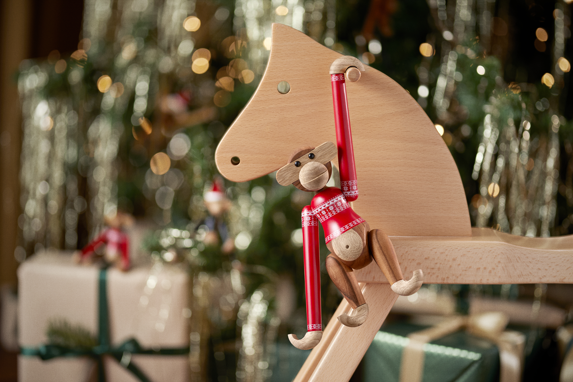 Kay Bojesen Affe im Weihnachtspullover auf Holzpferd, festliche Weihnachtsdekoration und Sammlerstück für das Jahr 2024.