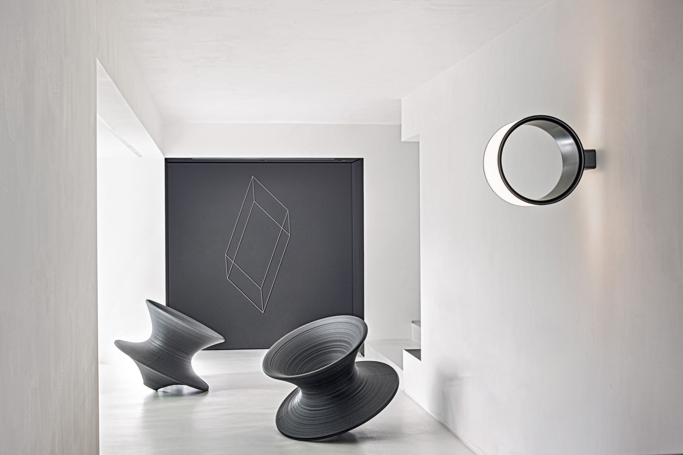 Helle, moderne Raumansicht mit Magis Lost Wandleuchte, runder Deckenlampe und Design-Skulpturen.