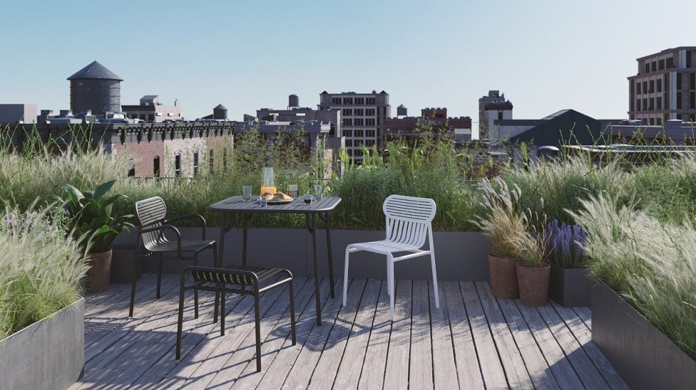 Week-End Square Table von Petite Friture auf einer Dachterrasse mit Stühlen und Stadtblick.