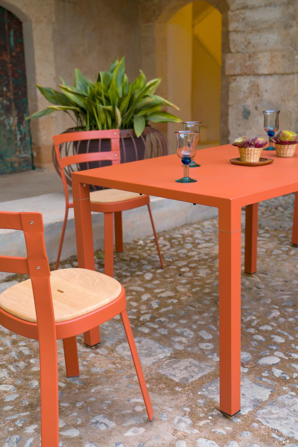 Orangefarbener Emu Hochtisch mit Stühlen für den Außenbereich, ideal für Garten und Terrasse.