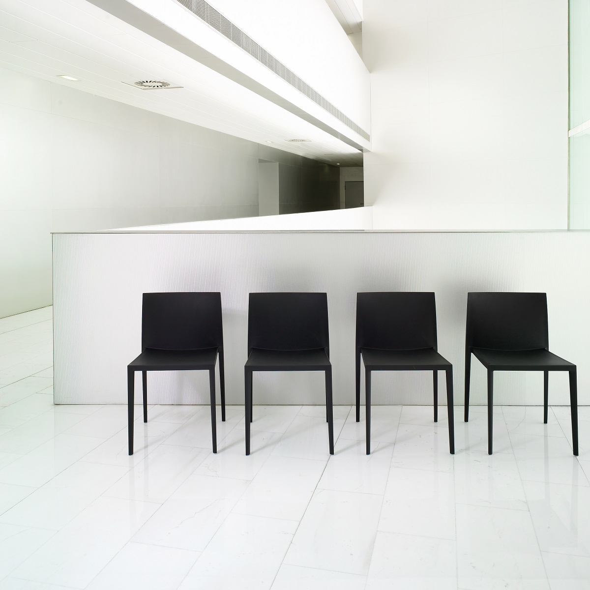 Vier schwarze Sail SI1245 Stühle von Andreu World, stapelbare Design-Stühle für Büro und Wartebereich.