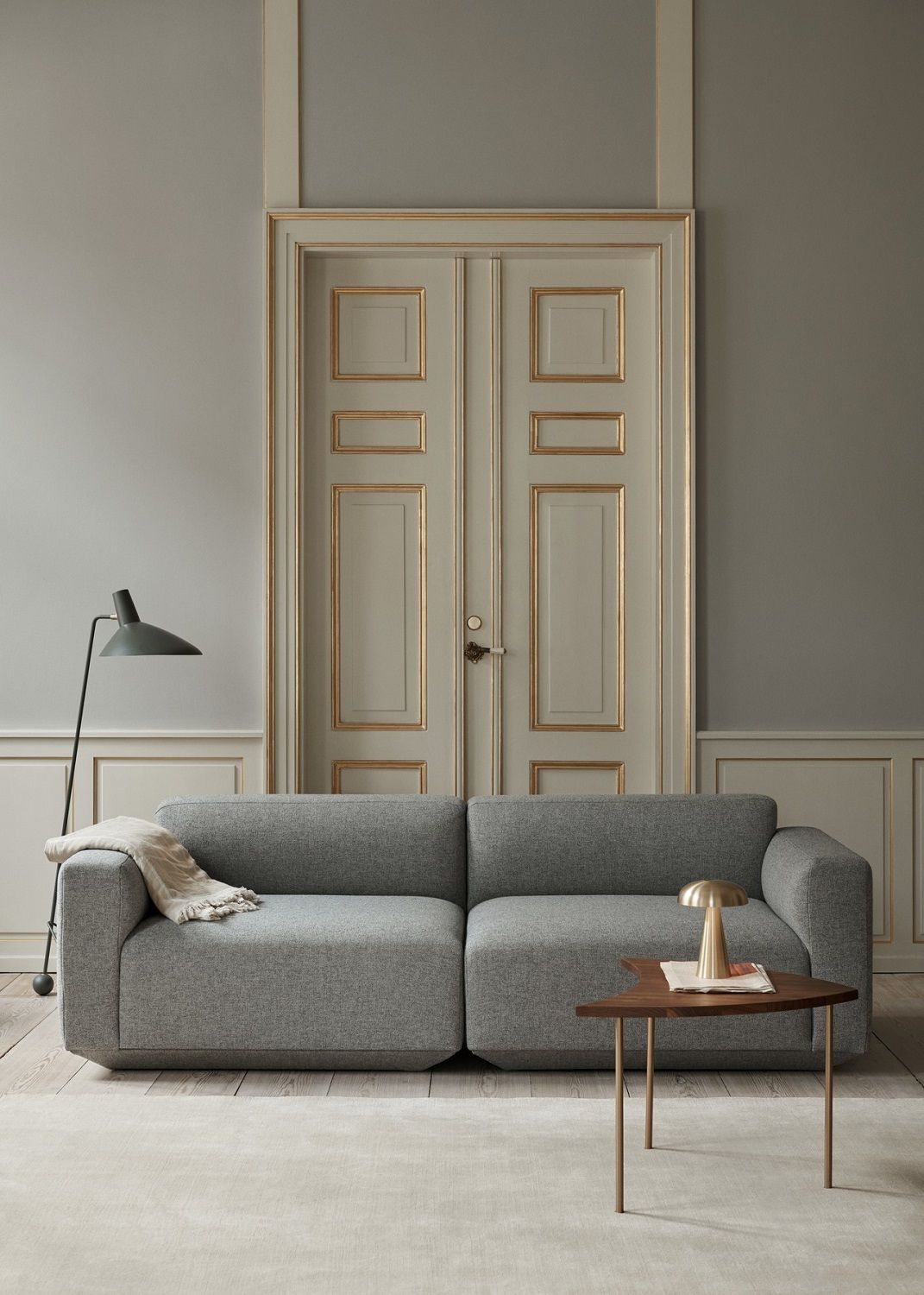 Graues Develius Sofa von AndTradition, Konfiguration A und B, mit Tischlampe und Decke im Wohnzimmer.