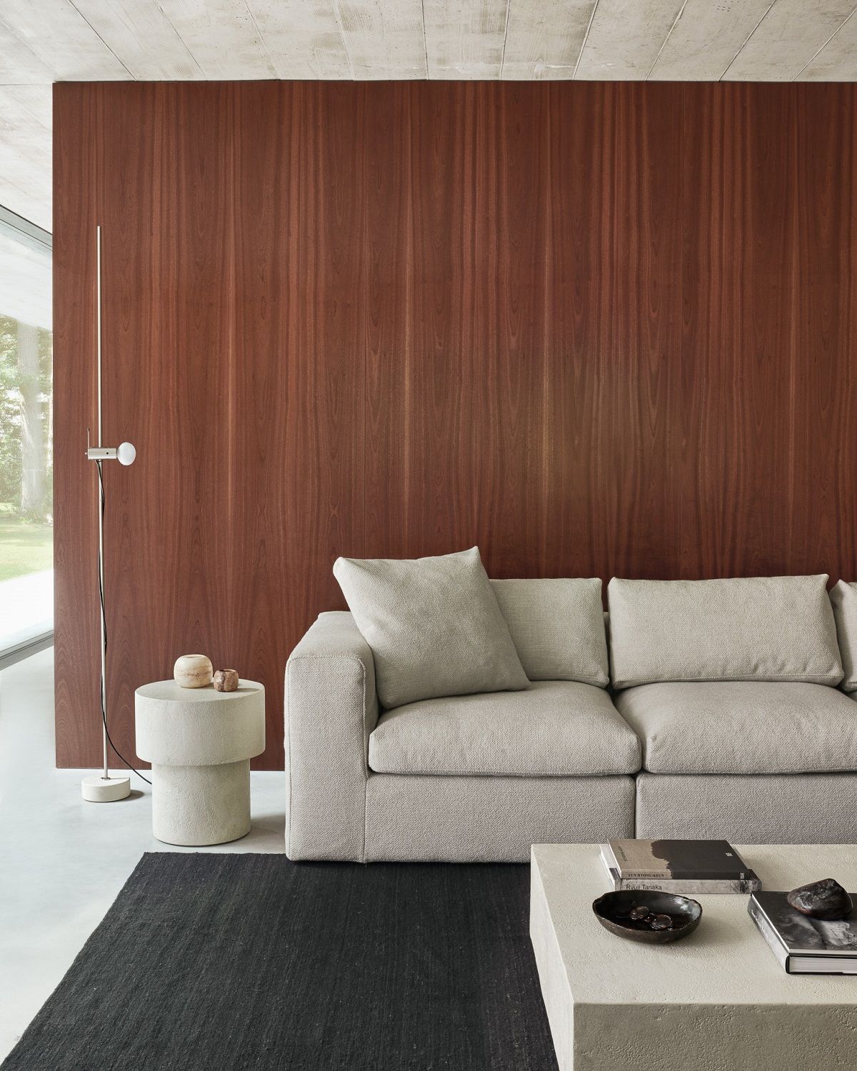 Elements Couchtisch von Ethnicraft in Off White mit Pilzform aus Microcement neben beigem Sofa.