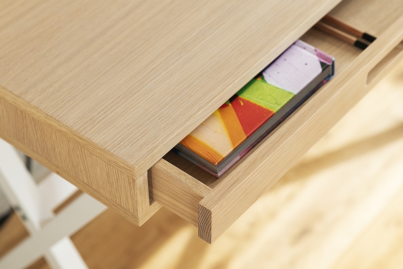 Detailaufnahme des Hyppolite Sekretär Hartô aus Eiche mit offener Schublade und bunten Büchern.
