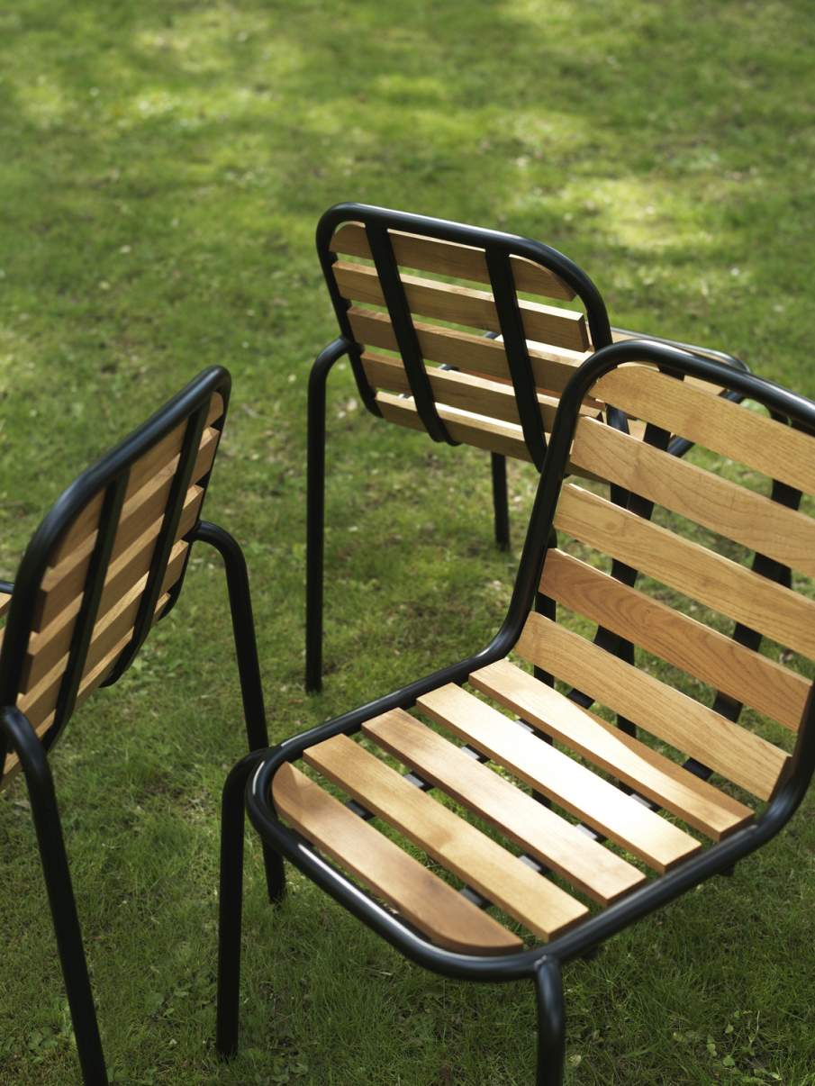 Drei Vig Chair Wood Stühle von Normann Copenhagen auf einer grünen Rasenfläche. Outdoor-Stühle aus Holz und Metall.