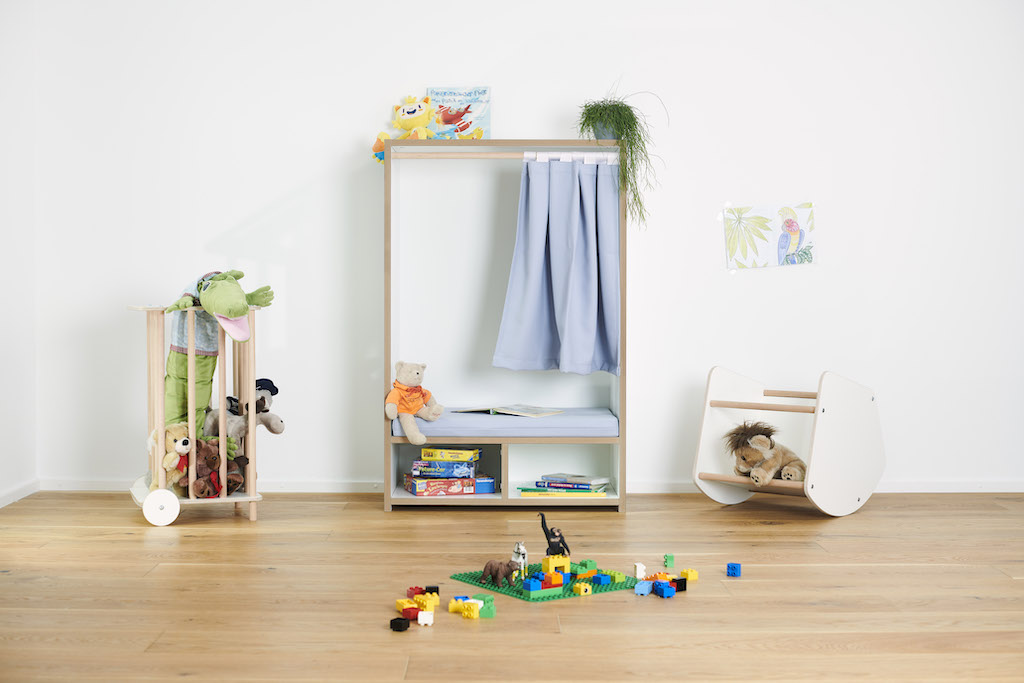 Tojo Kids Nische Lesebox im Kinderzimmer mit Spielzeug, Schaukelpferd und Bauklötzen auf hellem Holzboden.