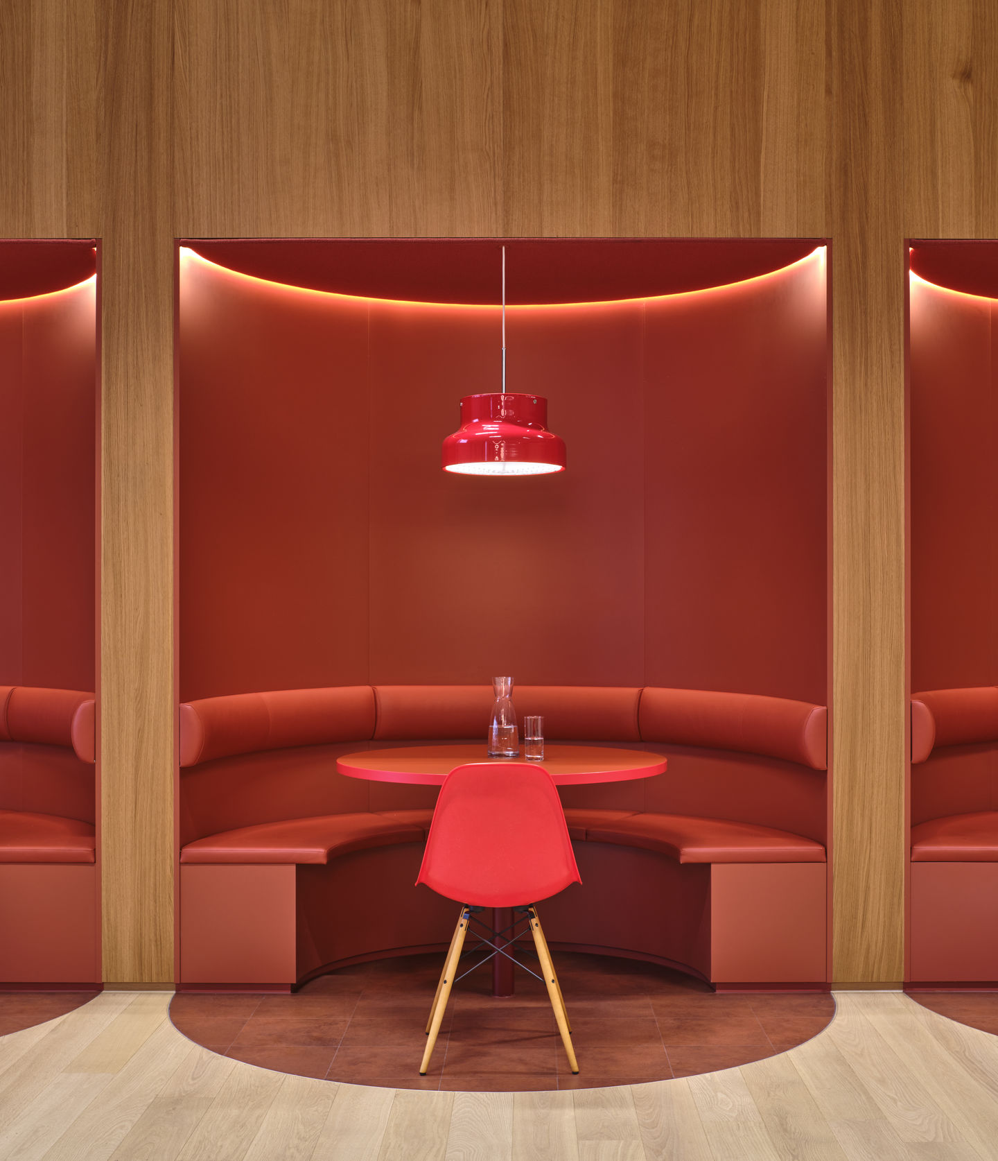 Roter Eames Fiberglass Chair DSW Stuhl von Vitra an rundem Tisch mit Sitzpolster in roter Sitzecke.