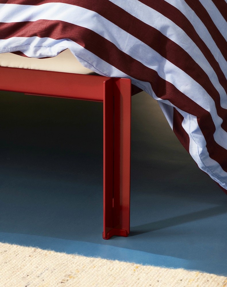 Detailaufnahme: Rotes Connect Bett von Hay (Bx160 cm) mit gestreifter Bettwäsche. Modernes Schlafzimmermöbel.